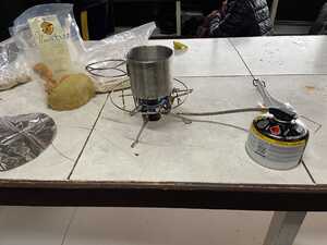 Camping stove on table with pot of water