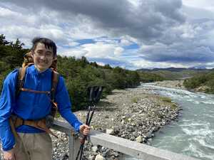 Asian man in blue jacked on bridge