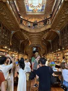 Crowded bookstore with staircase and gilded interior