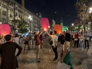 Men lighting a lantern in crowded square