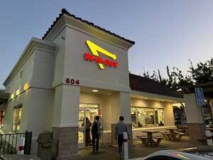 Fast food restaurant at night with lit up sign