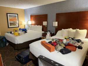 Hotel room with two beds full of camping gear