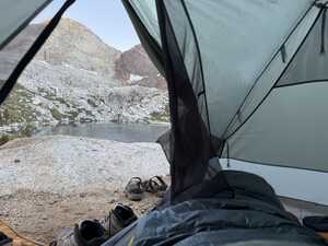 Picture from inside tent looking at lake and mountain