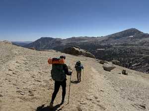 Two hikers going downhill on gravel