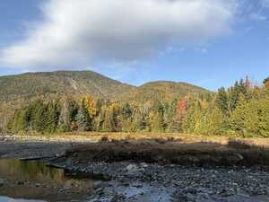 Mountains behind stream with fall foliage