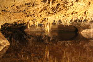 Lake inside a cave mirroring rock formation on roof