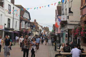 Town street lined with shops with many pedestians