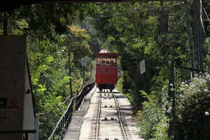 Red car on tracks on hill