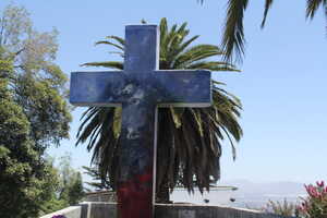 Painted cross in front of palm trees