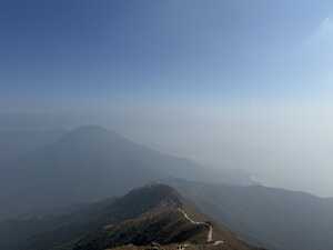 Mountain in mist with trail leading up to it