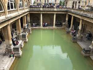 Large pool with green water, surrounded by colunnade