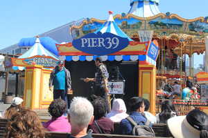 Man on stage in front of crowd with carnival background