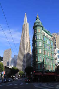 Narrow green building with tall pyramid behind