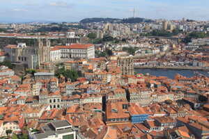 Looking out over city with red roofs and cathedral with river in background