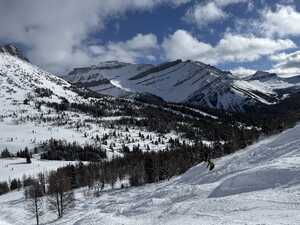 Ski slope with moguls and mountain in background