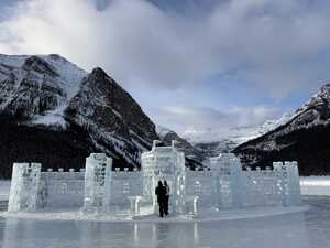 Ice castle on frozen lake with mountains