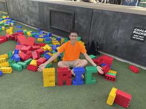 Man with his named spelled out in Lego blocks