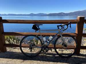 Bicycle in front of fence in front of lake