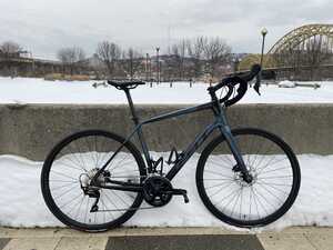 Bicycle in snow in front of concrete barrier