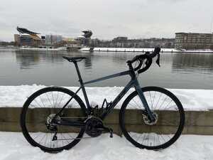 Bicycle in snow in front of river