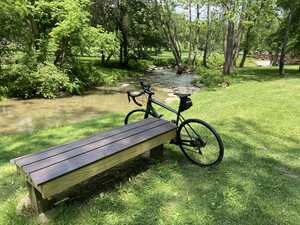 Bicycle and bench in front of creek