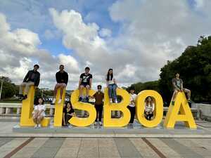 People taking picture with yellow Lisbon sign