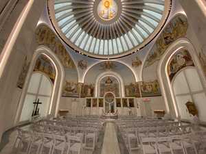 White modernist circular chapel with paintings