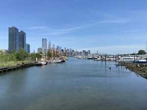 River with docked boats and skyline in background