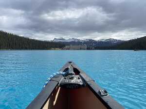 Front of canoe on lake with moutains in background