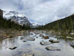 Rocks in the water in front of a mountain