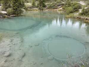 Blue pond with rings of sand on the bottom