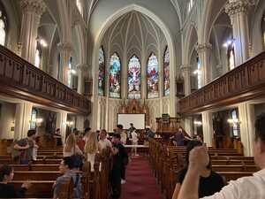 Two rowed church with stained glass and wooden pews