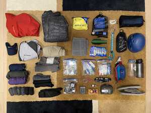 Backpacking gear laid out neatly on a rug