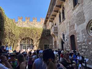 Small, crowded square with old stone balcony above