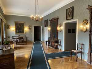 Room with doorways leading to corridors and paintings on the walls