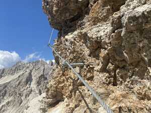 Steel cable going around rock wall outdoors