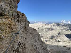 Steel cable going around ledge on mountain cliff