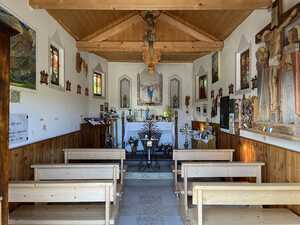 Interior of small chapel with many decorations on walls