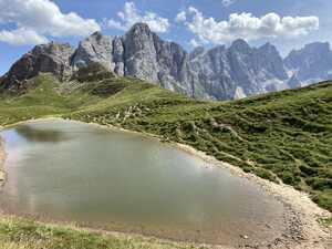 Pool of water in grass with mountains behind