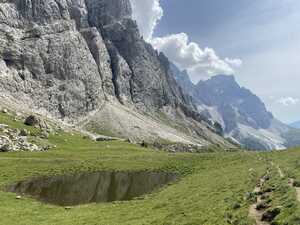 Pool of water in grass with mountains to left