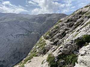 Trail in the side of a mountain with another mountain in the background