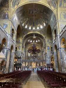 Interior of church with golden mosaics on tall ceiling