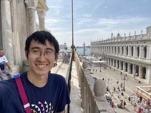 Asian man on roof in front of white marble colunnade