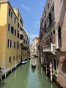 Canal between yellow and orange building with gondola in center