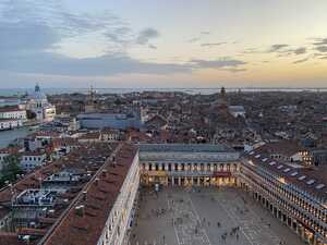 Looking down on old city at sunset with lights and red roofs