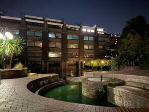 Brick fountain with pool of green water at night