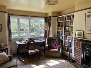 Old living room with bookshelf, desk, and armchair