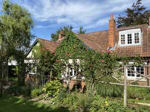 Old cottage with garden and fence in front