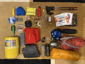 Camping gear laid out on carpet