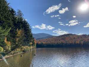 View of lake with fall foliage behind